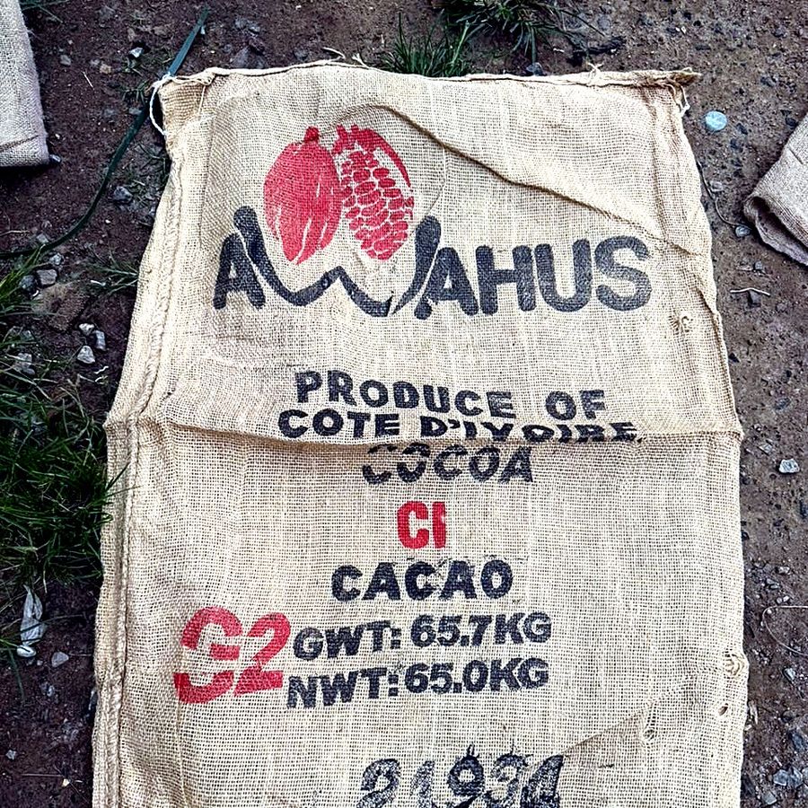 A worn, one-time-use grade jute bag on the warehouse floor