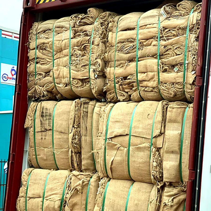 Bales of thin-weave jute sacks stacked in a shipping container